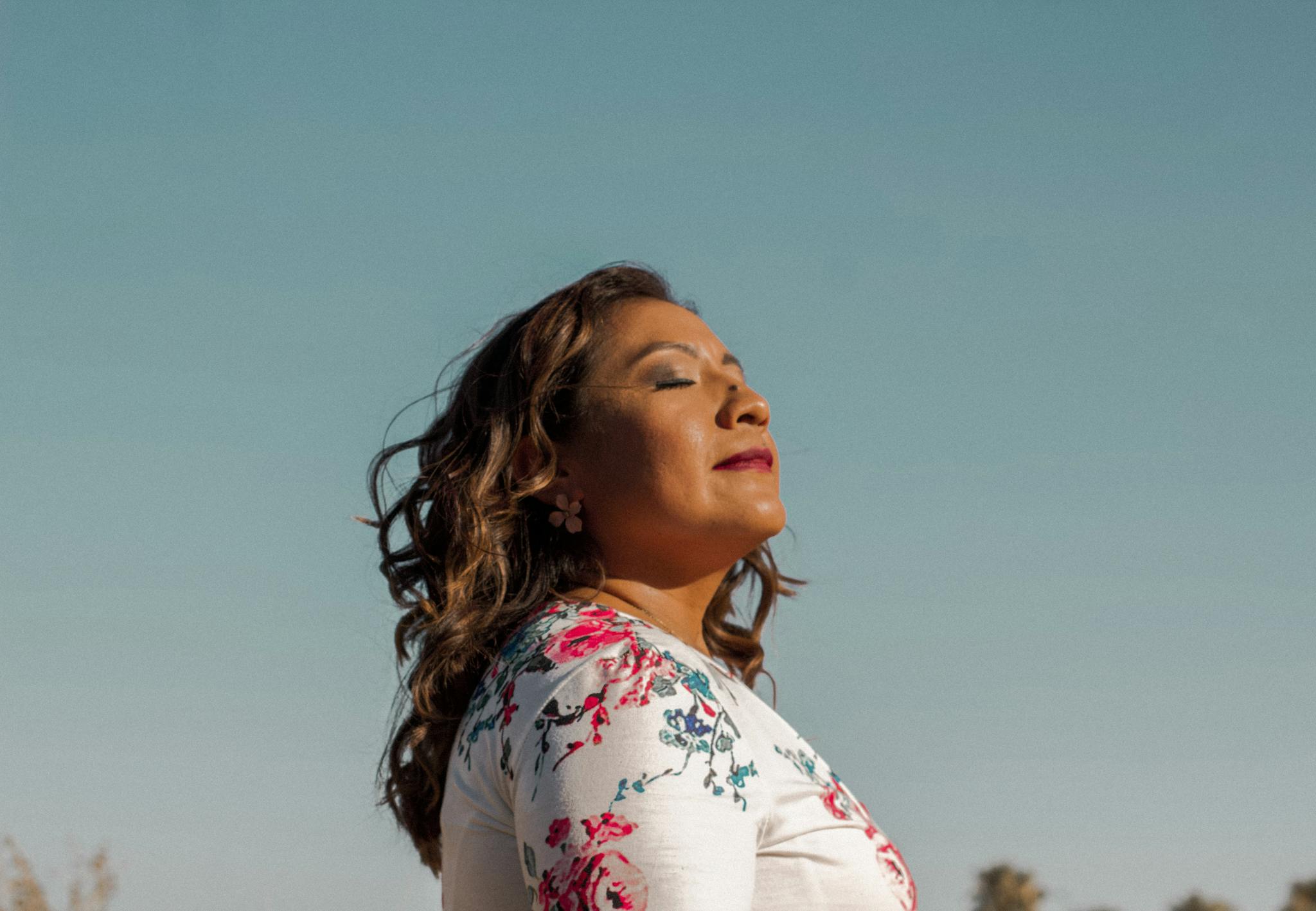 Side profile of a woman enjoying the sun outdoors, exuding calmness and confidence.
